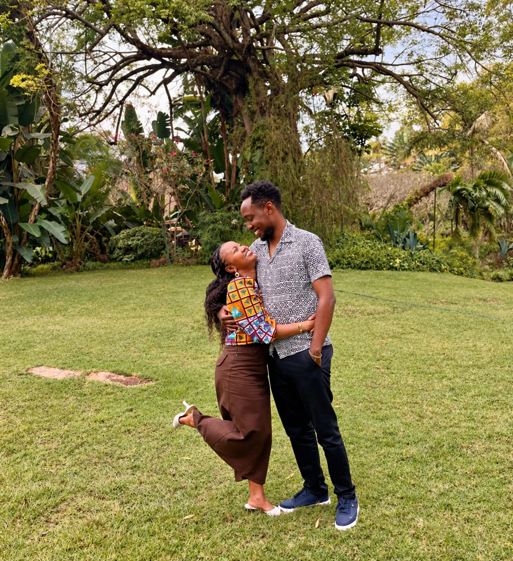 Grace and Nick smiling at each other in a garden, Grace lifting one foot