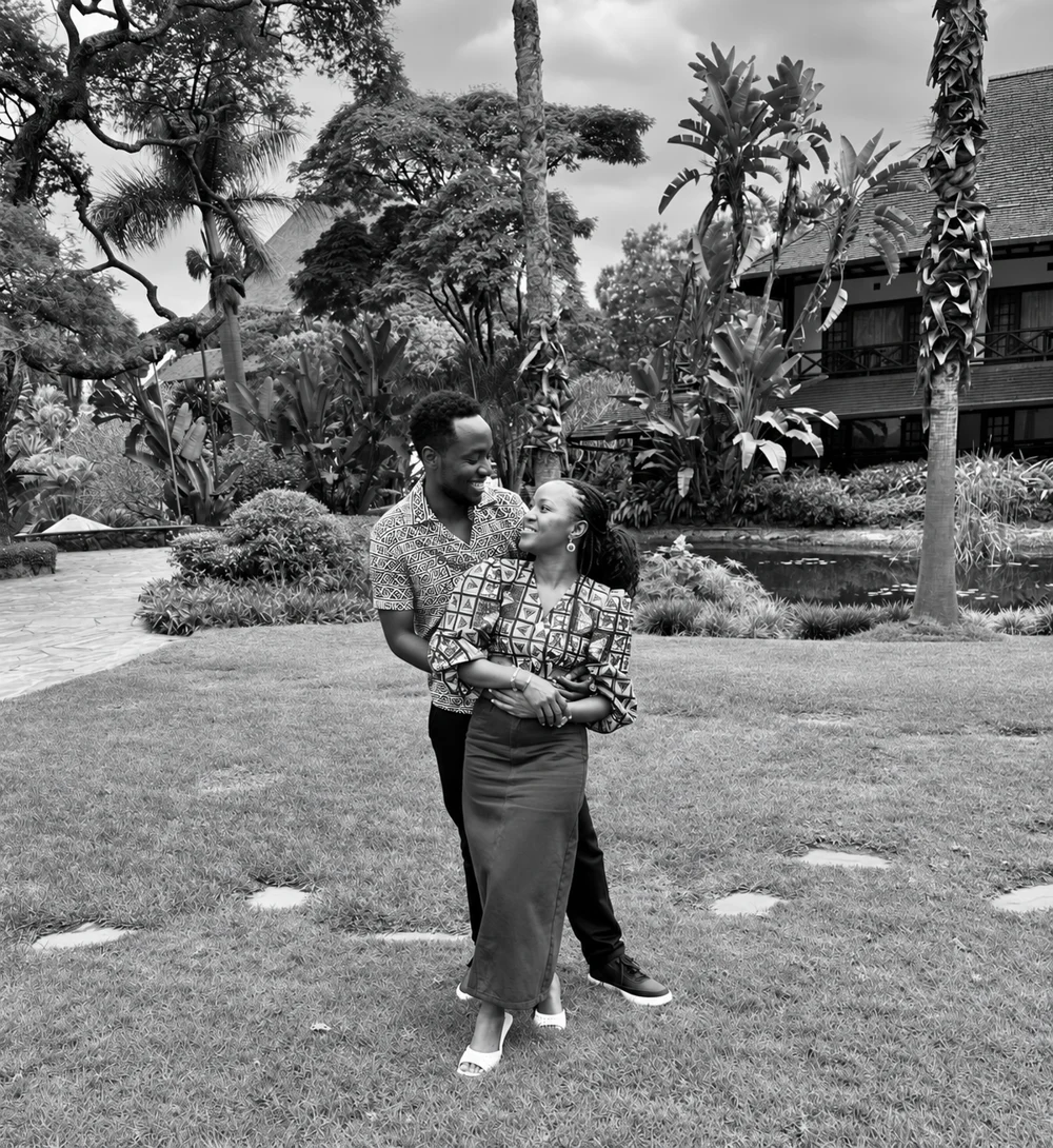 Black-and-white portrait of Grace and Nick holding each other and smiling in a garden